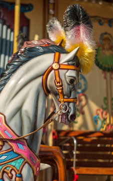Bright carousel in a holiday park. Horses on a traditional fairground vintage carousel. Merry-go-round with horses. (Real Photo)