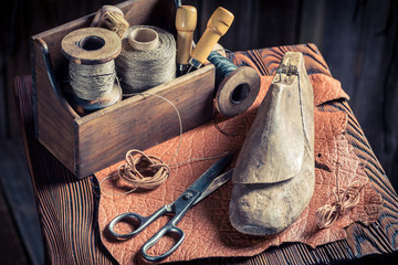 Small shoemaker workplace with tools, leather and shoes