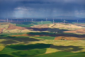Power plant and the rolling hills farmland with rain and sun. Palouse Hills in Washington, United State of America.