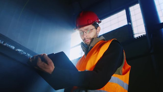 The builder or engineer working with documents against the window and the sun's rays