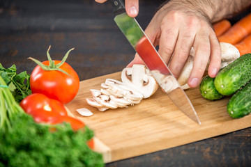 Male hands cutting vegetables for salad