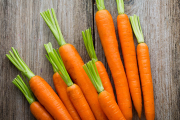 Fresh carrots bunch on rustic wooden background.