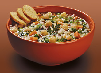 Orange bowl of rice soup with lentils and peas chickpeas