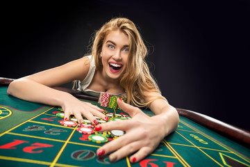 Young pretty women playing roulette wins at the casino