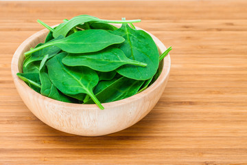 spinach leaf in wooden bowl on the wooden table