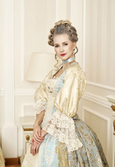 Beautiful woman in historical dress in Baroque style in the inte