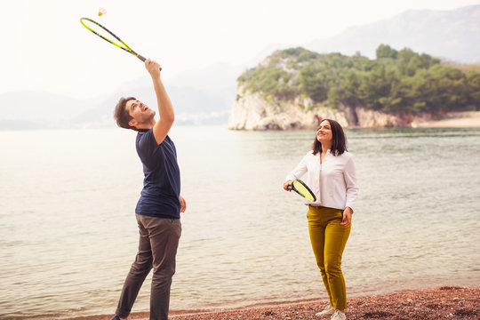Two young people playing on the seashore speedminton - badminton