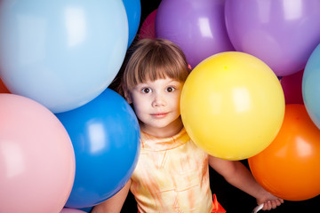 Fototapeta na wymiar Studio portrait of little blond girl with colorful balloons