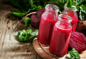 Fototapeta na wymiar Vitamin beetroot smoothie in glass bottles on the old wooden bac