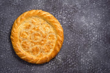 A white wholemeal bread roll on a grey background with copy space