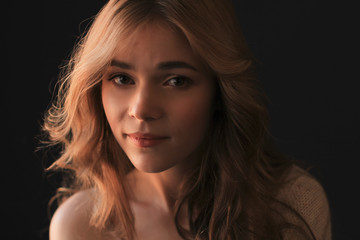 Fototapeta premium Portrait of tender blonde woman in the shadows