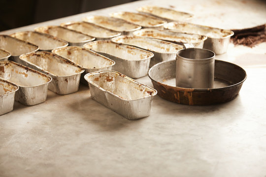 Set Of Baking Pan Molds For Cake Setted Up On Stone Marble Table And Ready To Be Filled With Cake Batter In Professional Artisan Bakery