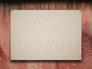 Fototapeta premium Close-up of one nailed blank poster canvas frame on red stained concrete wall background