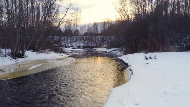 Sunset at river and forest. Aerial footage. Low altitude. Slow motion.