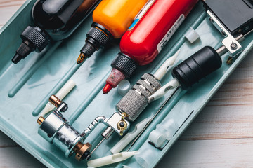 Replacement supplies for tattoo and tattoo machine on the white background of old boards