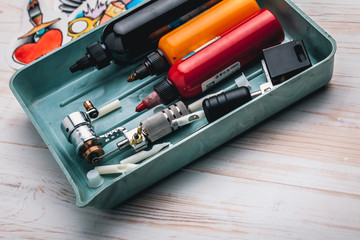 Replacement supplies for tattoo and tattoo machine on the white background of old boards