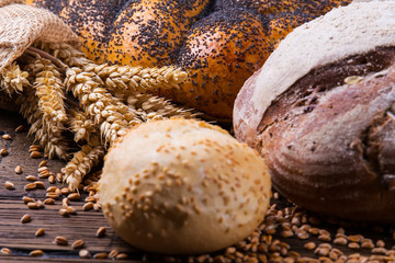 Assortment of baked bread on wooden table background