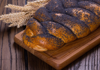 Assortment of baked bread on wooden table background
