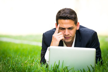 Young man working with his laptop outside