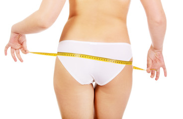 Young woman measuring her bottom