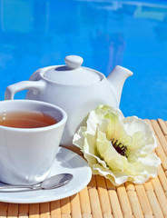 Cup of tea on a saucer and teapot.