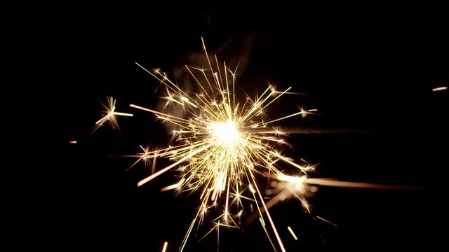 Sparkler burning from left to right in center of black background.  Recorded in 4K at 60fps.
