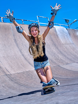 Teen skateboarding his skateboard hands up outdoor. Girl do  stunt .