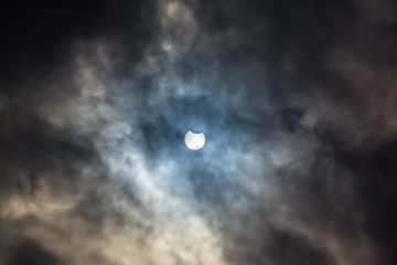 Naklejka na ściany i meble Solar eclipse on cloudy sky