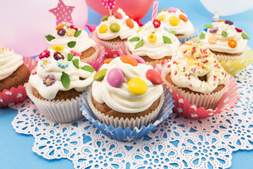 Fototapeta na wymiar Birthday cupcakes with balloons on a blue background