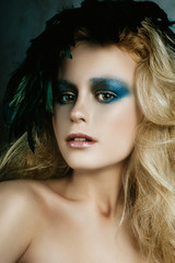 Fototapeta premium Beautiful girl in the image of bird with bright makeup, gold ha