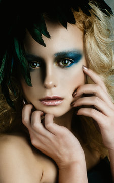 Beautiful girl in the image of bird with bright makeup,  gold ha
