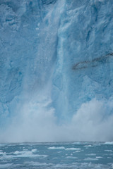 close up view of glacial ice crashing onto water