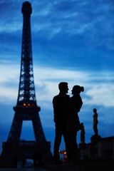 Silhouettes of young romantic couple near the Eiffel tower