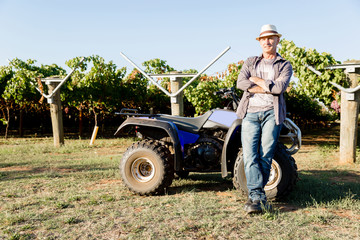 Obraz premium Man standing next to truck in vineyard