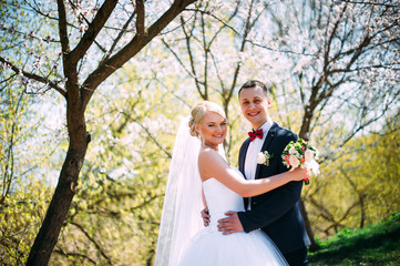 Kissing wedding couple in spring nature close-up portrait. Kissi