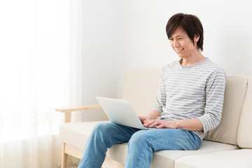 Fototapeta na wymiar young asian man using laptop computer