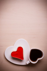 Heart shaped coffee cup and cake on wood surface
