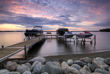 Boat dock at sunset with raised boats and jet ski's - Powered by Adobe