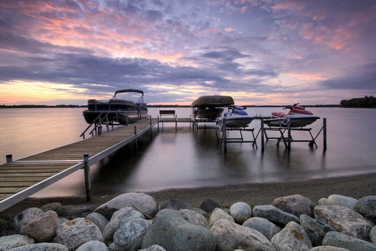 Boat dock at sunset with raised boats and jet ski's