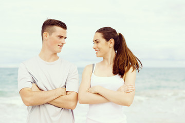 Young couple looking at each other while standing on beach