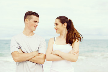 Fototapeta premium Young couple looking at each other while standing on beach
