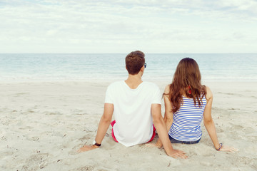Romantic young couple sitting on the beach