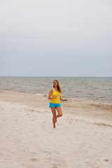 Fototapeta na wymiar Young woman running on the beach