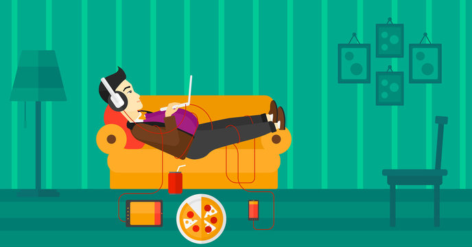 Man lying on sofa with many gadgets.
