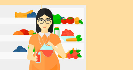 Pregnant woman standing near friedge.