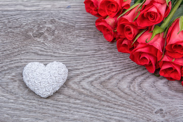 White heart and roses on a wooden background