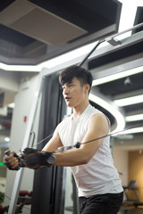 Fototapeta na wymiar young handsome asian man works out in modern gym