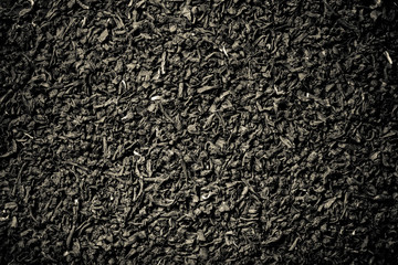 Dry black tea leaves as texture for background. Toned