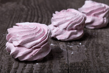Fresh pink homemade zephyr - marshmallow on old wooden table. Sh