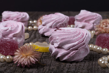 Fototapeta na wymiar Fresh pink homemade zephyr - marshmallow on old wooden table. Sh